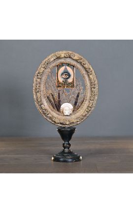 Cadre ovale "Memento Mori au 3ème œil" présenté sur support en bois